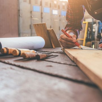 Carpenter working with equipment on wooden table in carpentry shop. woman works in a carpentry shop.